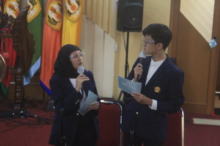 MC session during the National Seminar PERETETA FTIP, with two masters of ceremonies reading the program script on stage.